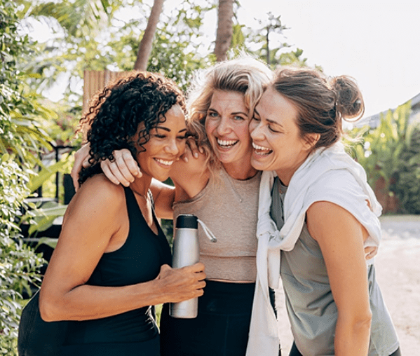 Women hugging and smiling outdoors